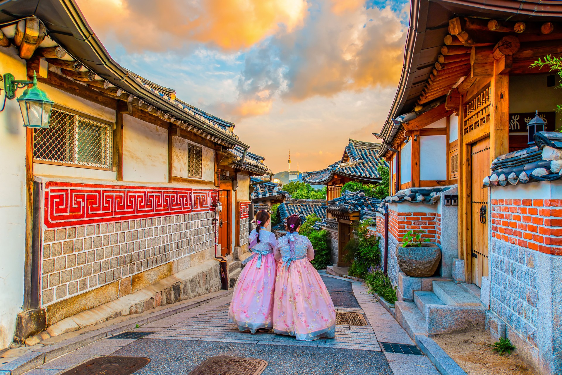 Rear View Of Woman Walking Amidst Buildings Against Sky
